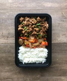 a black container filled with rice and meat