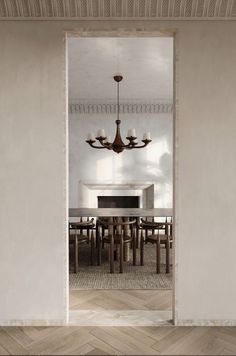 an open door leading to a dining room with a chandelier hanging from the ceiling