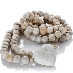 a bracelet with stones and a heart shaped rock on the end, sitting in front of a white background