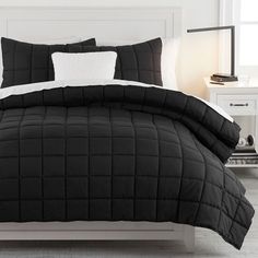 a bed with black and white comforters in a bedroom