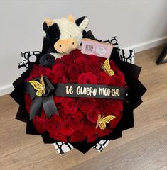 a bouquet of red roses with a teddy bear on top and the words te quiepa moo gho written on it