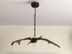 an antler's head is hanging from a light fixture in a living room