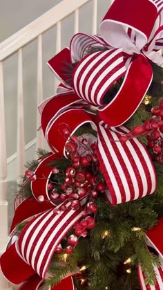 a christmas tree decorated with red and white ribbons