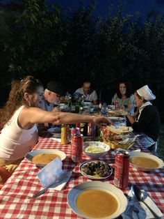 a group of people sitting around a table with food on it