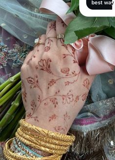 a woman's hand with henna and bracelets on it