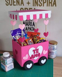 a pink cart filled with candy on top of a table