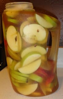 a pitcher filled with sliced apples on top of a counter