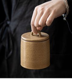 a person holding onto a small wooden container