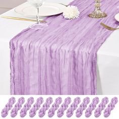 the table is set with purple linens and place settings for two people to sit at