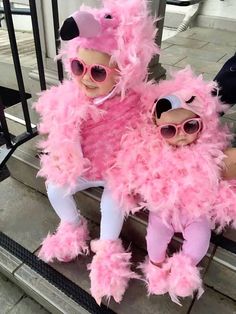 two dolls dressed in pink and white sitting next to each other on a stair case