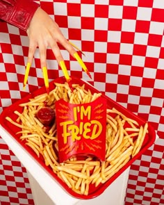 a person reaching into a container filled with fries