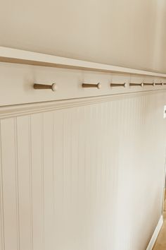 a room with white paneling and wood floors