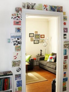 a living room filled with furniture and lots of pictures on the wall next to a doorway