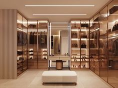 a walk - in closet with lots of clothes and shoes on shelves, along with a bench