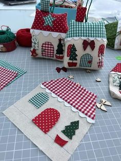 several small bags are sitting on the table with christmas decorations in them and one is made out of fabric