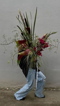 a person walking down the street with a bouquet on his back and flowers in their hands