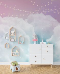 a child's room decorated in pastel colors with clouds and stars on the wall