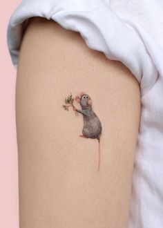 a small mouse tattoo on the right side of the thigh, with a tiny flower in it