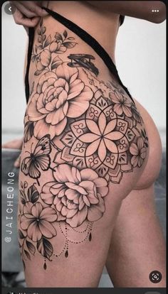 a woman's thigh with flowers and butterflies on the side, in black and white