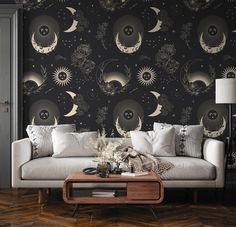 a living room filled with furniture and wallpaper covered in black and white moon designs