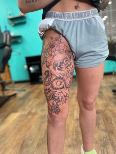 a woman's legs with tattoos on them and flowers in the middle of her leg