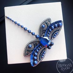 a blue beaded necklace on a white card