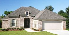 a brick house with two garages in the front yard