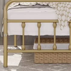 a gold metal bed frame with white sheets and pillows