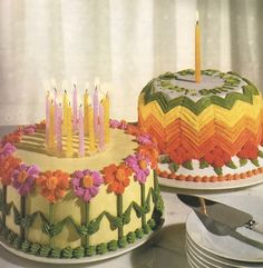 there are two cakes with candles on them and one is decorated in yellow, pink, orange and green