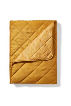 an orange quilted blanket on a white background