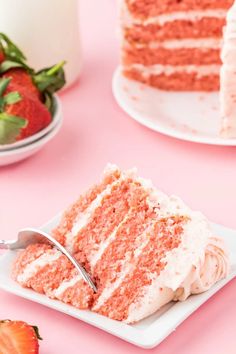 a slice of red velvet cake with white frosting and strawberries on the side