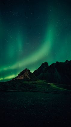 the northern lights shine brightly in the sky above mountains