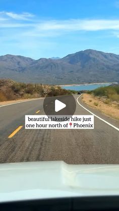 a car driving down the road with mountains in the background and a sign that says beautiful lakeside hike just one hour north of phoenix