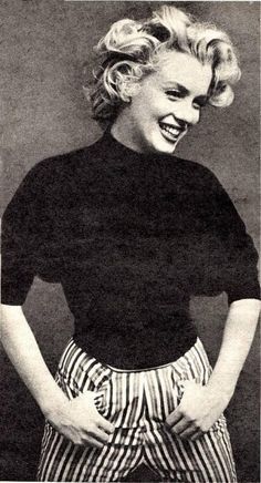 an old photo of a woman with her hands on her hips and smiling at the camera