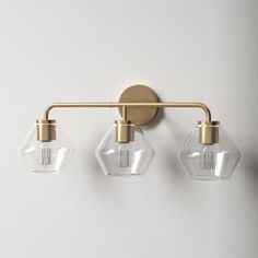 three light brass bathroom fixture with clear glass shades