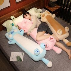 a woman laying on top of a bed covered in stuffed animals and teddy bear pillows