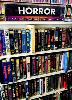 a book shelf filled with lots of books next to each other on top of white shelves