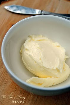 a white bowl filled with butter on top of a wooden table