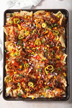 a tray filled with nachos covered in toppings