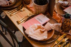 a wooden table topped with plates and utensils