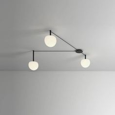 three lights are hanging from the ceiling in an empty room