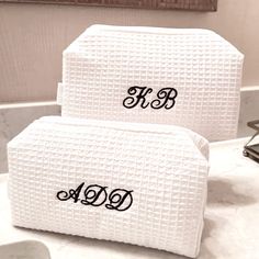 two white towels sitting on top of a bathroom counter next to each other with the word monogrammed on them