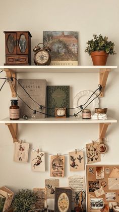 two shelves with pictures, clocks and other items on them in a room that has white walls