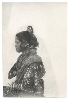 an old black and white photo of a woman with her hair in a pony tail