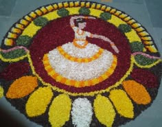 a colorful flower design on the ground with white and yellow flowers in front of it