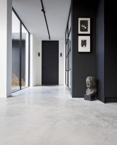 a black and white hallway with two sculptures on the wall next to eachother