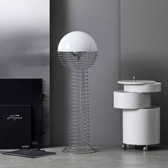 a white lamp sitting on top of a table next to a box and other items