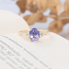 a tan and purple ring sitting on top of an open book