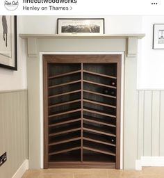 an empty wine cellar in the corner of a room with pictures on the wall above it