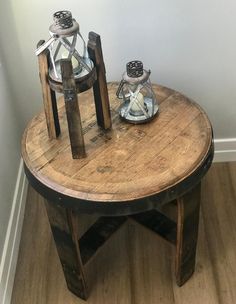 an old wooden table with two glass jars on it and a candle holder sitting on top